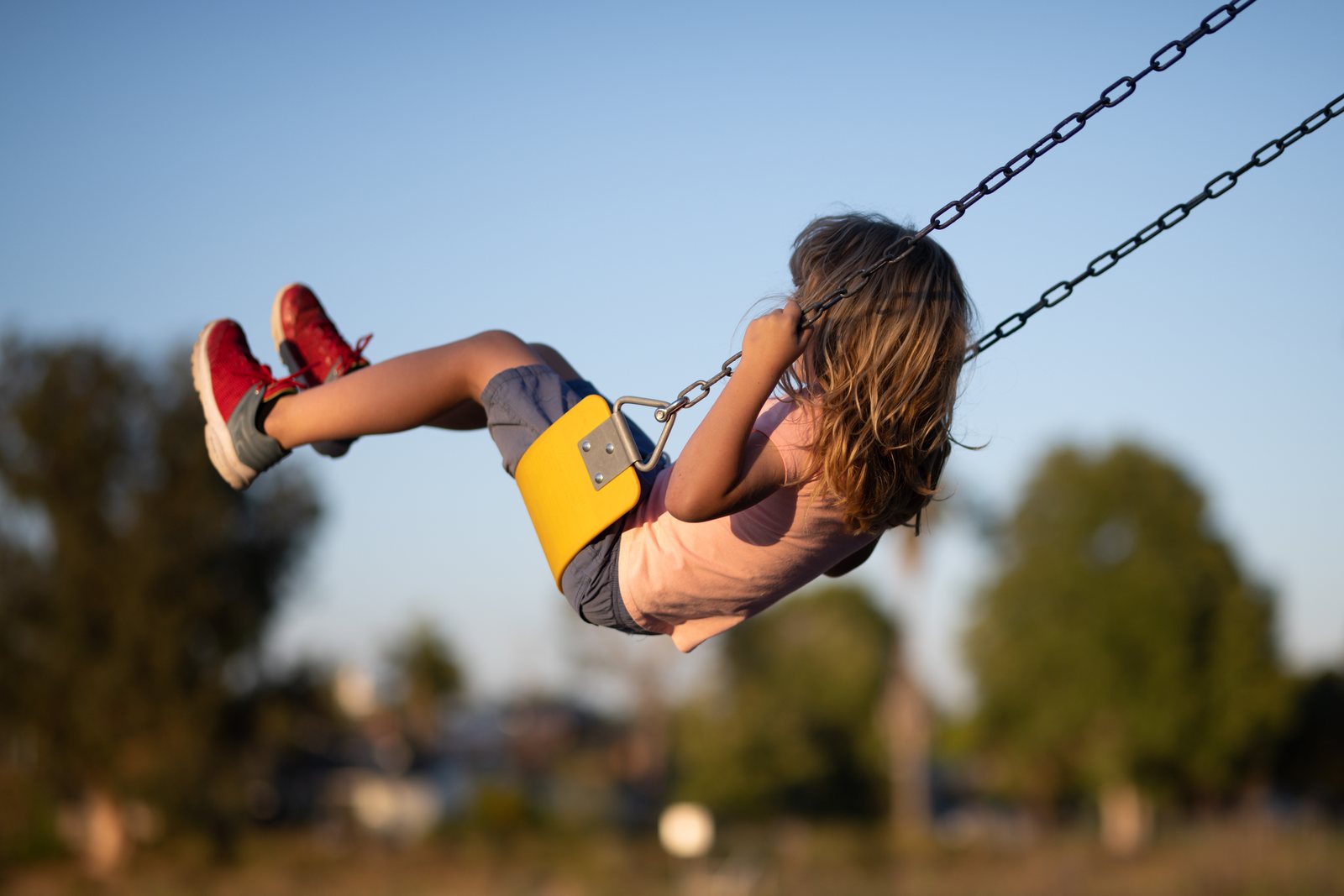 Child playing on a park swing at golden hour in Kemptville